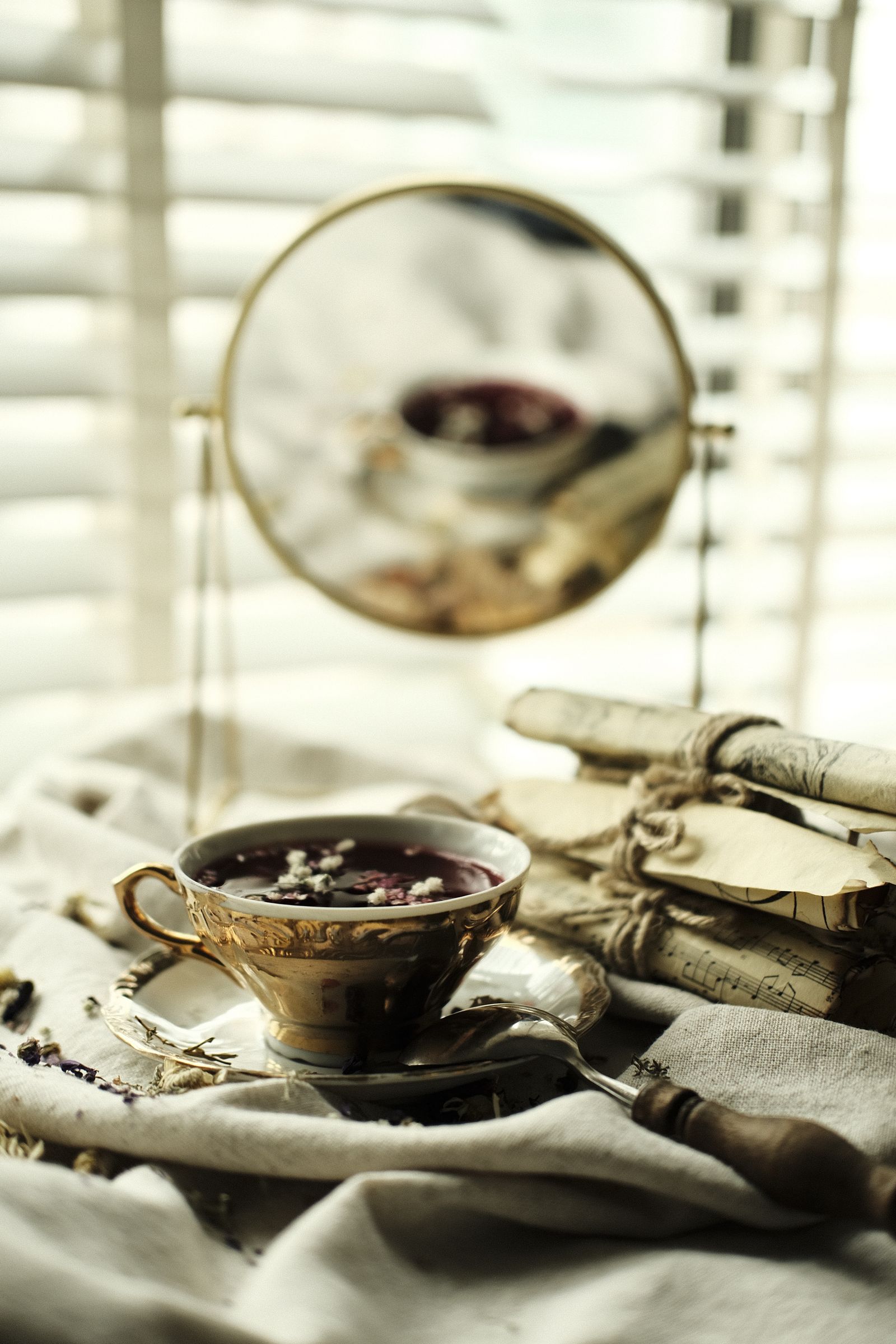 A classic tea cup reflected beside a warm tea setting