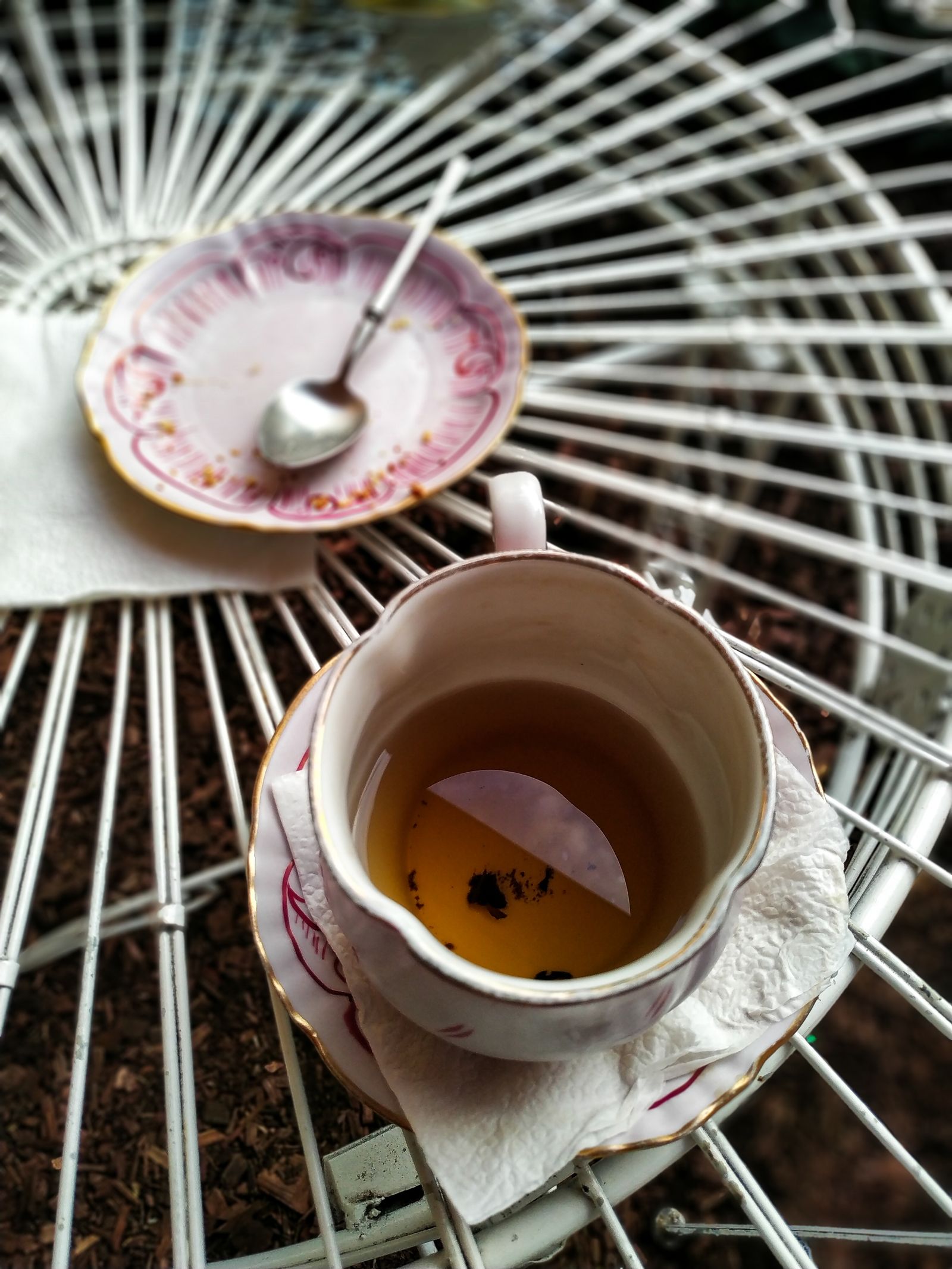 A freshly brewed cup of tea beside loose tea leaves